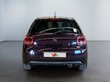 the rear end of a purple car in a room with a white wall