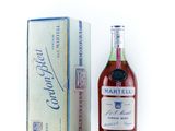 La bouteille de cognac se trouve à côté d'un carton de vin