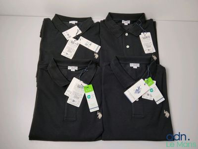 deux polos noirs pour homme, encore étiquetés, posés sur une table