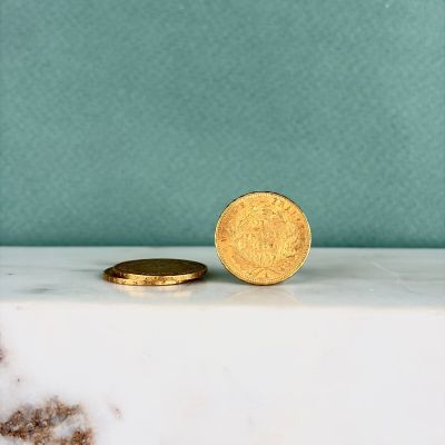 une pièce d'or posée sur un comptoir en marbre