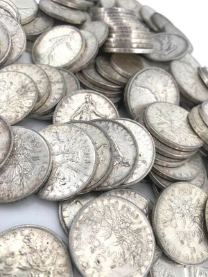 une pile de pièces d'argent posée sur une surface blanche