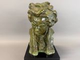 bronze sculpture of a man with a hat on his head on a black base
