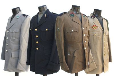 Trois uniformes militaires pour hommes sont alignés sur un présentoir à mannequins