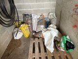 un tas d'ordures posé sur une palette près d'un mur