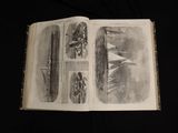 an open book with drawings on it on a black surface