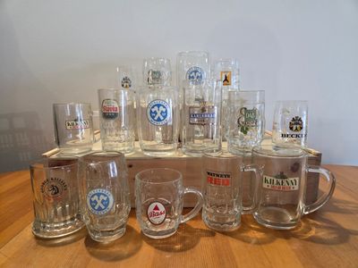 a lot of beer glasses sitting on a wooden table