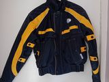 une veste de moto jaune et noire accrochée au mur devant une porte blanche