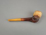 a pipe that has a face on it and a wooden handle