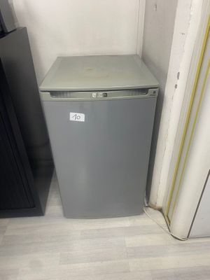 un petit réfrigérateur dans un coin de la pièce