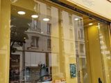 des tables et des chaises disposées à l'extérieur d'un magasin, sur le trottoir