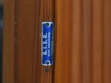 a close up of a blue sign on a wooden fence