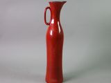 a red vase that is sitting on a table