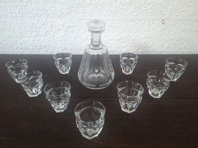 plusieurs verres et une carafe posés sur une table