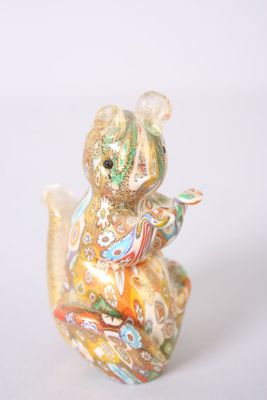 une petite figurine représentant un ours en peluche assis sur une table