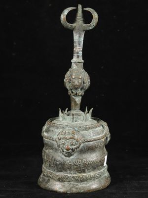 an old bronze bell with a cross on top of it on a black background