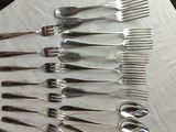 a lot of forks and spoons sitting on a table