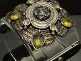 silver cuff bracelet with yellow and black stones on a black surface