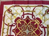 a red and white scarf with gold designs on it