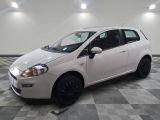 la petite voiture blanche est garée sur un carrelage à carreaux