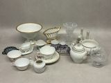 a lot of white and gold dishes and cups on the table