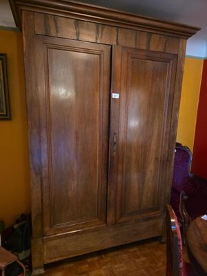 a wooden armoire in the corner of a room