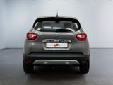 the rear end of a silver car parked in a white room