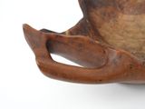 a wooden bowl with a handle on a white surface