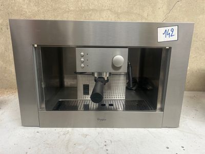 une machine à café en acier inoxydable posée sur un plan de travail devant un mur
