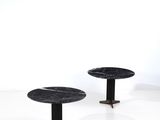trois tables en marbre noir reposent sur une surface blanche