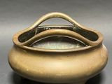an image of a small bronze pot with a handle