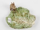 a figurine of a rabbit on top of a cabbage leaf
