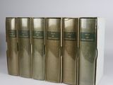 three books are lined up in a row on a white surface