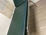 une chaise verte qui se trouve dans un coin de la pièce