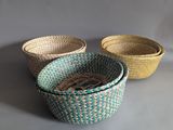 three woven baskets are lined up on a gray surface