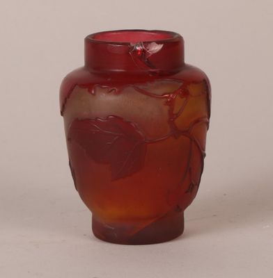 a red vase with a leaf design on it