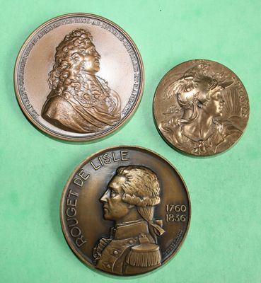three different types of bronze coins on a green surface
