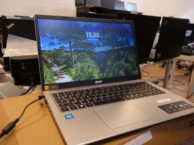 a laptop that is sitting on a table in front of a bunch of monitors