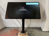 a computer monitor sitting on a stand in a room