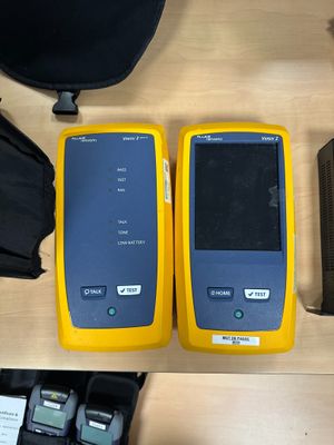 two yellow and black cell phones sitting next to each other on a table