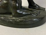 a bronze statue of a cat sitting on a base