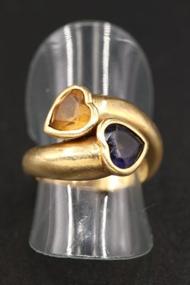 une image représentant une bague en or ornée de deux cœurs et d'un saphir