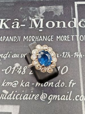 une bague sertie d'une pierre bleue, posée sur un morceau de papier