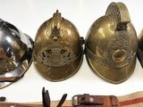 several different types of fire helmets are lined up on a table