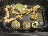 un plateau noir sur lequel sont disposés plusieurs bijoux en or