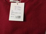 a close up of a red sweater with a tag on it