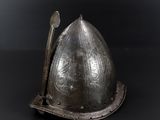an old helmet with a stick sticking out of it on a black surface