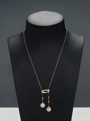 a necklace with a coin and a chain on a mannequin