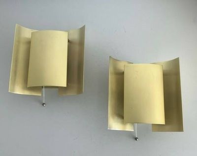 pair of brass wall sconces with curved shades on each of them