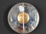 a picture of a silver plate with a gold medal on it