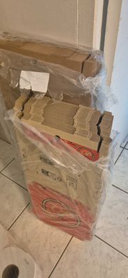 a box of toilet paper sitting on the floor next to a roll of toilet paper